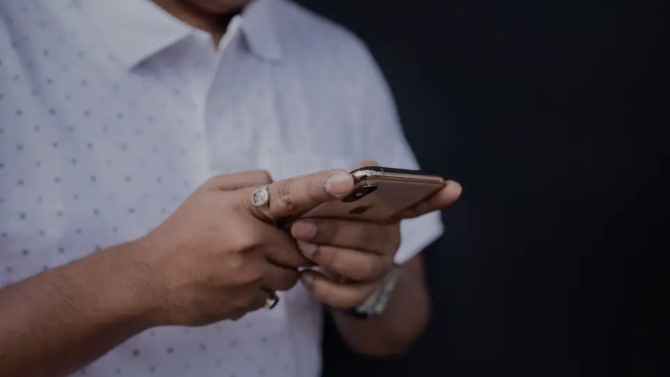 Hands holding a phone and typing a message